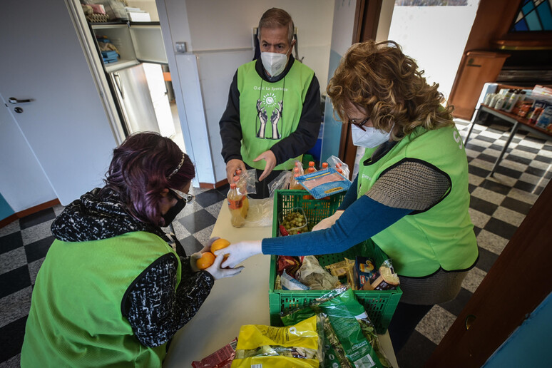 Volontari distribuiscono generi alimentari - RIPRODUZIONE RISERVATA