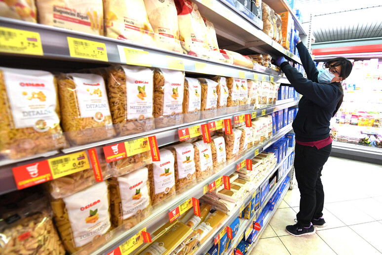 Personale di un supermercato allestisce uno scaffale - RIPRODUZIONE RISERVATA