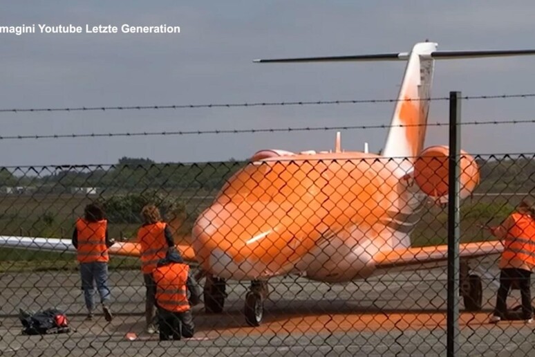 Ecoattivisti mentre imbrattano un jet privato in Germania, la settimana scorsa - RIPRODUZIONE RISERVATA