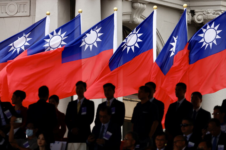 Attendees stand in front Taiwan national flags - RIPRODUZIONE RISERVATA