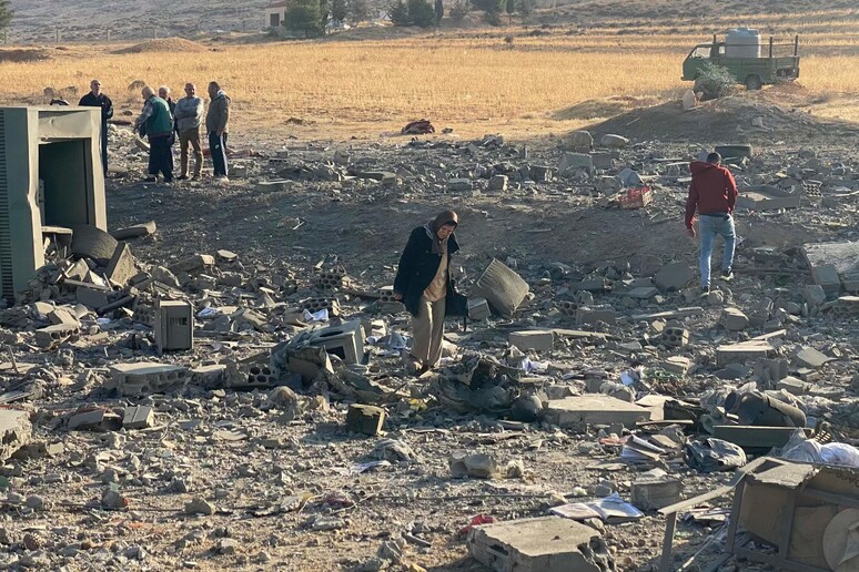 People inspect the damage at the site of an Israeli airstrike © ANSA/AFP