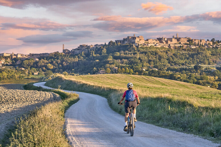 Una donna in bici elettrica nella regione del Chianti in Toscana foto iStock. - RIPRODUZIONE RISERVATA