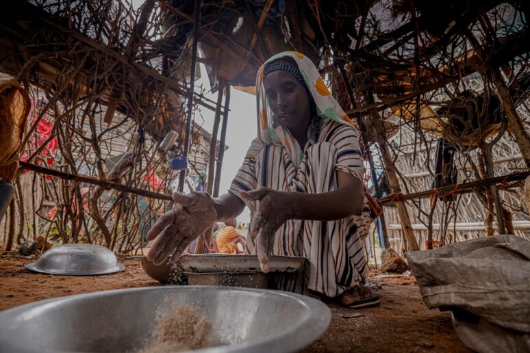 Una donna prepara un pasto in Somalia - RIPRODUZIONE RISERVATA