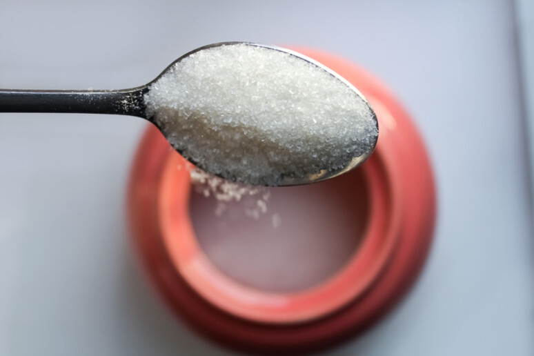 Pour sugar from a spoon. - RIPRODUZIONE RISERVATA