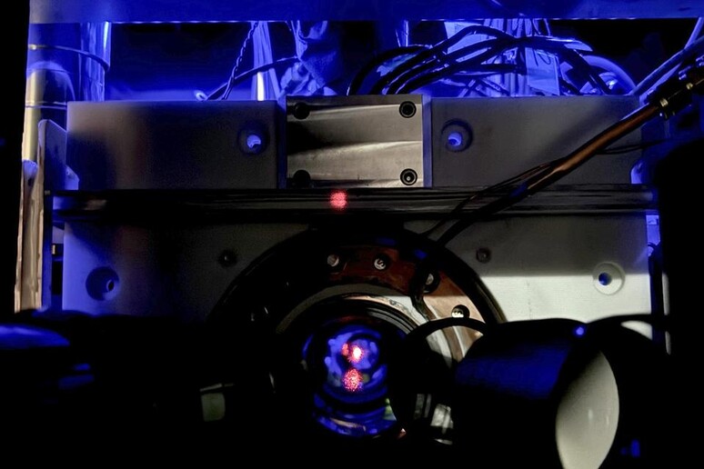 Nel nuovo orologio atomico la luce laser (in rosso) crea una trappola (reticolo ottico) per gli atomi (fonte: K. Palubicki/NIST) - RIPRODUZIONE RISERVATA
